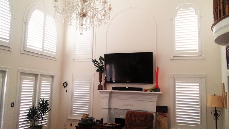 San Antonio great room with mounted television and arched windows.